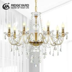 a chandelier hanging from the ceiling in a room with white walls and curtains