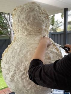 a person is working on a large white teddy bear