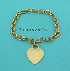 TIFFANY & Co. 18K Gold Heart Tag Charm Bracelet 8" Metal: 18K Yellow Gold Weight: 25.40 grams Length: 8". It could be adjusted to fit smaller wrist by moving the lobster clasp to any link on the bracelet Hallmark: "©TIFFANY&Co. 750" on the heart tag and "750" on the clasp Condition: Pre-owned, good condition, comes with Tiffany pouch, box, bag and ribbon Value: $6,200 Authenticity Guaranteed Tiffany Charm Bracelets Tiffany & Co., Tiffany Gold, Tiffany Setting, Gold Heart Bracelet, Tiffany Diamond, Modern Bracelets, Aquamarine Necklace, Heart Tag, Gilded Age