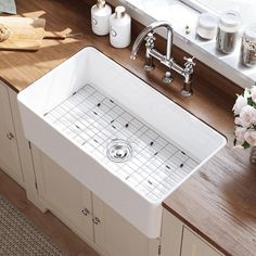 a white kitchen sink sitting on top of a counter next to a wooden cutting board