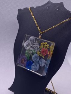 The chain is 18" long and displays beautiful genuine dried and pressed flowers preserved in resin. This piece is unique and come beautifully packaged in it's own gift bag, ready to gift to your loved ones, or even to yourself! Necklace chain is .925 sterling gold and hypoallergenic. Thanks for your support of my small business! Please contact me for any questions about your purchase and I also do custom jewelry upon request! Have a good day! Rectangular Birth Flower Necklace As Gift, Resin Birth Flower Necklaces For Jewelry Making, Resin Necklace With Pressed Flower Pendant, Resin Necklace With Flower Pendant For Birth Flower, Resin Birth Flower Pendant Necklace, Nature-inspired Rectangular Jewelry For Gifts, Nature-inspired Rectangular Jewelry Gift, Clear Flower-shaped Necklace For Gift, Pressed Flowers Resin Jewelry As A Gift For Her