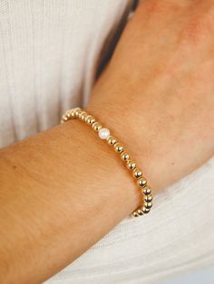 It's always a party on your wrist when you add these leMel gold fill stretch beaded bracelets to your wrist stack! These are made with 5mm 14k gold fill beads on stretch cord with a fresh water pearl. The gold fill beads are very durable and keep their shiny gold color! Perfect to wear alone or with your other leMel favorites! Dainty Adjustable Pearl Stretch Bracelet, Elegant Hypoallergenic Gold Stretch Bracelet, Elegant Everyday Pearl Stretch Bracelet, Classic Adjustable Gold Bracelet With Pearls, Elegant Stretch Bracelet With Pearl Charm And Round Beads, Classic Gold Pearl Bracelet Hypoallergenic, Adjustable Stretch Bracelet With Pearl Charm For Everyday, Elegant Adjustable Stretch Bracelet With Pearl Charm, Elegant Stretch Bracelet With Pearl Charm As Gift