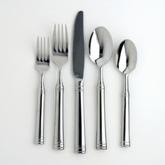 four forks, two knives and three spoons on a white surface