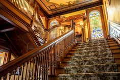 an ornate staircase with stained glass windows and wooden handrails