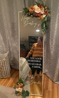 a person standing in front of a mirror with flowers on it and the words, happy birthday