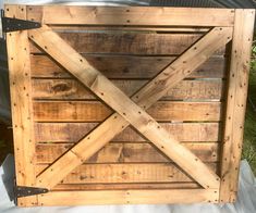 a close up of a wooden gate on a white sheet with grass in the background