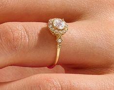 a woman's hand with a diamond ring on top of her finger and an engagement band