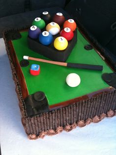 a cake shaped like a pool table with balls and cues