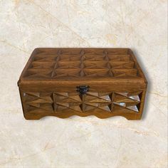 a wooden box sitting on top of a marble floor