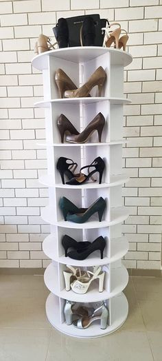 there is a white shelf with many pairs of shoes on it