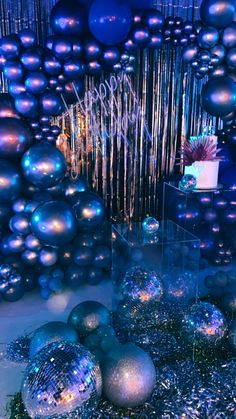 blue and silver christmas balls in front of a large number of shiny tinsels