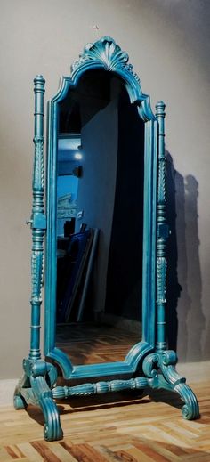 a blue mirror sitting on top of a wooden floor