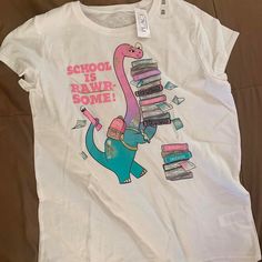 New With Rage It Is A Kids Size Xxl (16) With Dinosaur Print In The Middle Carrying Books. There Is Glitter Attached And It Is Loose Shirt. Dinosaur Shirt, School Tops, Purple Girls, Girls Graphic Tee, Loose Shirt, Loose Shirts, Green Shirt, Grey Shirt, Dinosaur Print