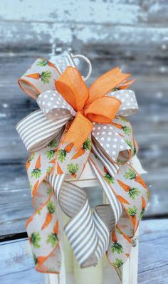 an orange and white bow on top of a lantern