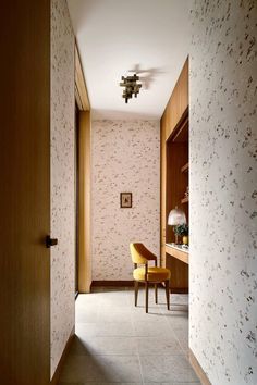 a hallway with a chair and desk in it