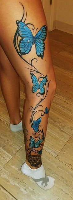 a woman's legs with blue butterflies on them