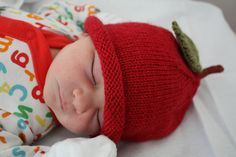 a baby is wearing a red hat and sleeping