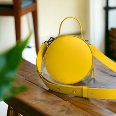 "A round tote  bag  with a handle will help to emphasize your femininity, it will always effectively emphasize your image and will help to free your hands from the little things that always clutter up your pockets. The leather work tote bag not only complements your style, but also becomes a roomy bag for every day, work or walk. The yellow color of the skin, the quality of work, the silhouette of the bag are created for a true connoisseur of beauty. Product information:  *  Italian leather  * skin color yellow   * the bag has a large main compartment, an adjustable shoulder strap and a handle for carrying the bag in hand  * 100% handmade   * Dimensions: diameter 9.05 \" -  23 cm   thickness 3.14\"  -  8 cm  *Strap size: width 1,57\" - 4 сm length 51,18\" -  130сm     *Handle size: width Cheap Eco-friendly Yellow Shoulder Bag, Modern Luxury Yellow Box Bag, On-the-go Shoulder Bag With Round Handle, On-the-go Satchel With Round Handle, Modern Bags With Detachable Strap And Round Case, Modern Round Case Shoulder Bag For Daily Use, Round Case Bag With Detachable Handle, Chic Round Bag For Daily Use, Chic Round Bags For Daily Use