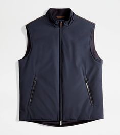 Gilet with leather ribbing on the shoulders, two slanted pockets and double-slider zip. Crafted in comfortable stretch fabric, with water-repellent, windproof and breathable membrane, it is lined in wool jersey. A versatile urban garment enriched by refined iconic detailing: the rectangular leather patch on the back with stamped Tod's logo, collar band and shaped zip pulls, inspired by the historic Greca Belt buckle. Blue Back, Gift Boutique, Leather Patches, Trainers Women, Mens Trainers, Mens Belts, Belt Buckle, Belt Buckles, Water Repellent