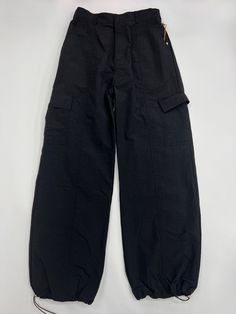 100% Nylon Loose Fit Pants Oversized Pockets on both legs Adjustable toggles at hem Baggy Wide-leg Parachute Pants For Outdoor Activities, Solid Color Wide Leg Parachute Pants For Outdoor, Wide Leg Parachute Pants For Outdoor, Full Length Parachute Pants With Elastic Waistband For Outdoor, Parachute Pants With Pockets For Outdoor Activities, Baggy Solid Color Utility Parachute Pants, Solid Color Baggy Utility Parachute Pants, Baggy Solid Parachute Pants For Outdoor, Baggy Solid Utility Parachute Pants