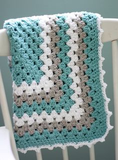 a crocheted blanket sitting on top of a white chair