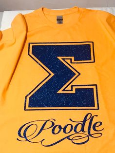 a yellow shirt with the letter z and poodle written in blue ink on it