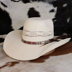 The Resistol Young Gun Jr. Youth Cowboy Hat combines style and durability with its rough-and-tough Bangora construction, featuring a 4 3/4" rounded brick crown and a 4” brim. The hat's unique design includes a feather and a Native American-inspired pattern on the hatband, making it a standout accessory for young cowboys and cowgirls. With an elastic sweatband to accommodate size changes, this hat is a versatile and practical choice for children as they grow and explore the great outdoors. Brim - 4" Crown - 4 1/4" Bangora Straw Western Hats With Adjustable Fit For Country Events, Adjustable Country Hats For Western-themed Events, Adjustable Country Style Hat Band For Country Events, Country Style Adjustable Hat Band For Country Events, Adjustable Fit Country Style Hat Band For Country Events, Country Style Short Brim Hat For Rodeo, Western Sun Hat With Adjustable Fit, Adjustable Western Hat Bands For Country Events, Adjustable Fit Western Sun Hat