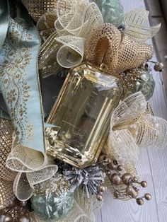 a close up of a wreath with a perfume bottle on it and decorations around it