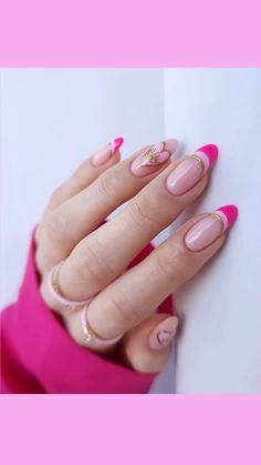 a woman's hand with pink and gold manies on her nails, against a white wall