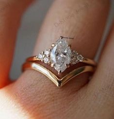 a woman's hand with a gold and white diamond ring on top of her finger