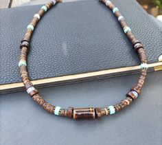 Embrace the laid-back vibes of summer with this stylish boho surf necklace, crafted for those who love to stand out. This unique piece features a harmonious blend of Turquoise, Blue Spot Agate, Ceramic, Wood, and Coconut beads, making it a versatile accessory for any wardrobe. Perfect for beach days, festivals, or adding a touch of nature-inspired elegance to your everyday look. Turquoise: Turquoise is renowned for its protective and healing properties. It promotes tranquility, relieves stress, Casual Brown Necklaces For The Beach, Casual Brown Necklace For Beach, Artisan Beaded Necklace With Gemstone Beads For Beach, Artisan Brown Beaded Necklace For Beach, Casual Brown Beaded Necklace For Beach, Casual Brown Beaded Necklace For The Beach, Earthy Adjustable Beads For Beach, Earthy Adjustable Beach Beads, Beach Necklace With Brown Round Beads