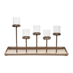 four glass candle holders on a metal tray