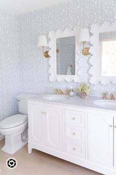 a white bathroom with two sinks and a toilet in it's centerpieces