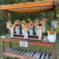 an outdoor stand with flowers on display for sale