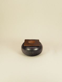 a small wooden object sitting on top of a white surface