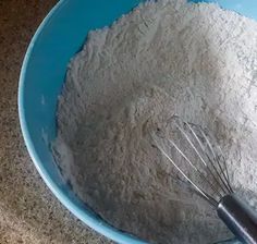 a whisk in a blue bowl with flour