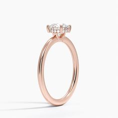 a rose gold engagement ring with two diamonds on the top and side stones in the middle