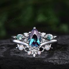 "This is a lab Alexandrite engagement ring in solid gold,about 6x8mm 1.3ct pear cut.  The accent stones are round 1.5mm moissanites and marquise cut 2x4mm moss agates. The matching band stones are round lab opals. The band width about 1.3-1.4mm. It can be made in any ring size. However please contact me to custom make it to a special big or small size. It can be made in white gold,rose gold or yellow gold with 14k or 18k. However for some people who are nickel allergic,I can also make it to 925 sterling silver to make you can wear it. The ring is handmade,very high quality! 30 days money back guarantee. Returns & Warranty 30-Day money back guarantee (starting from the day of delivery). \"Made to Order\" purchases qualify for our 30-day money back guarantee. The 30-day money back guarantee Alexandrite Engagement Ring Silver, Alexandrite Engagement Ring, 18k Gold Jewelry, Engagement Ring Set, Bridal Ring Set, Ring Women, Pretty Rings, Matching Band, Opal Ring