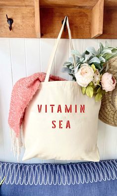 The VITAMIN SEA over sized canvas tote bag is perfect minimalist bag for a trip to the beach!  Available with text in several colors... check out the variations!  This bag is made from 100% thick, sturdy canvas. AVAILABLE IN TWO SIZES * Large - 19.5" x 13" with a 4" gusset *Jumbo - 23" x 13" with a 6" gusset   These bags are hand painted using non-toxic fabric paint.  The technique used creates an attractive distressed appearance to the text that varies from bag to bag.  All of my products are m Large Capacity Canvas Tote Bag For Beach Season, Large Capacity Summer Canvas Bag For Everyday Use, Trendy Canvas Bag For Beach Season, Trendy Canvas Beach Bag For Beach Season, Large Capacity Canvas Bag For Everyday Summer Use, Large Capacity Canvas Tote For Beach Season, Summer Cotton Bags For Beach Season, Cotton Beach Bags For Daily Use, Summer Beige Cotton Canvas Bag