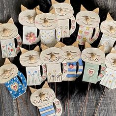 a bunch of cat pins sitting on top of a wooden table next to each other