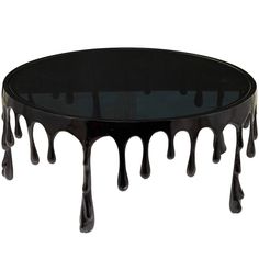 a glass table with dripping black paint on it