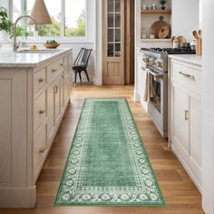 a green runner rug in the middle of a kitchen