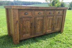 a wooden cabinet sitting on top of a lush green field