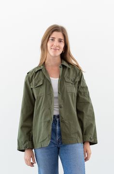 "Olive green jacket shirt with button closure and two front chest pockets, epaulettes. Maker: Military  |  Made in USA.  |  Material: Cotton Poplin Condition: Excellent.   X-SMALL: Shoulders: 16\"  |  Chest: 19\"  |  Length: 25\"  |  Sleeve: 22\" SMALL: Shoulders: 16.5\"  |  Chest: 21\"  |  Length: 25\"  |  Sleeve: 22\" Alex is 5'5\" and wears a modern small. She is wearing the X-SMALL here. SHOP http://www.rawsonstudio.etsy.com FOLLOW US + instagram | @_rawson + pinterest | rawson **No Returns. Items are eligible for store credit only. We ask that the buyer ship to provided address and a credit code is issued for one year.**" Khaki Utility Jacket With Patch Pockets, Military Style Khaki Utility Jacket With Buttoned Pockets, Casual Khaki Shacket With Buttoned Pockets, Khaki Utility Shacket With Flap Pockets, Casual Khaki Utility Jacket With Buttoned Pockets, Fall Khaki Tops With Buttoned Pockets, Olive Button-up Outerwear With Patch Pockets, Olive Button-up Cotton Outerwear, Button-up Utility Jacket With Patch Pockets