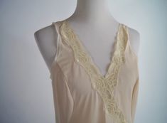 "This is a lovely vintage slip by A&M that was made in Egypt. It is a blush pink half slip with lace trim and insets. It hits at the knee. It is in excellent condition. Size: Small Bust: 35\" Waist: 32\" hips: 42\" Length: 40\"" Beige Camisole For Daywear, Vintage Lace Trim Camisole For Spring, Fitted Cream Camisole With Lace Trim, Cream Lace Camisole For Daywear, Spring Cream Camisole For Daywear, Cream Camisole For Spring Daywear, Cream Lace Trim Camisole For Daywear, Beige Lace Trim Camisole For Daywear, Liquid Satin