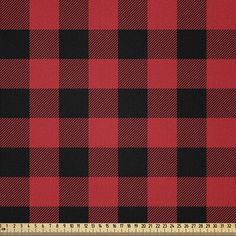 a red and black checkered fabric with a ruler in front of the plaid pattern