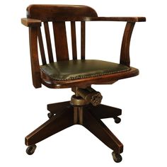 a wooden desk chair with leather seat and casteor wheels on an isolated white background