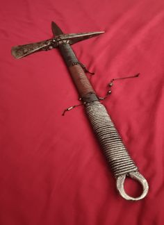 an old knife laying on top of a red sheet