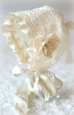 a close up of a flower on a white surface with small beads and bows around it