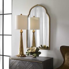 a table with two lamps and a mirror on it